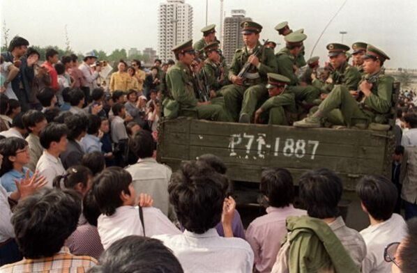 BEIJING, CHINA - MAY 21:  Pro-democracy demonstrators surround a truck filled of People's Liberation Army (PLO) soldiers 20 May 1989 in Beijing on their way to Tiananmen Square 20 May 1989 after the Martial Law was proclaimed in Beijing 20 May. In a show of force, 04 June, China leaders vented their fury and frustration on student dissidents and their pro-democracy supporters. Several hundred people have been killed and thousands wounded when soldiers moved on Tiananmen Square during a violent military crackdown ending six weeks of student demonstrations.  (Photo credit should read CATHERINE HENRIETTE/AFP/Getty Images)